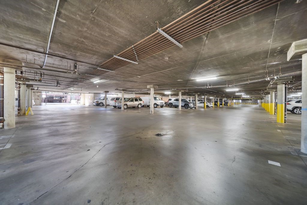 A spacious parking garage with multiple cars parked.