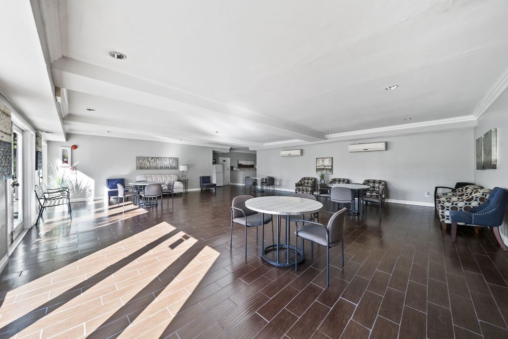 A spacious room with a table and chairs.