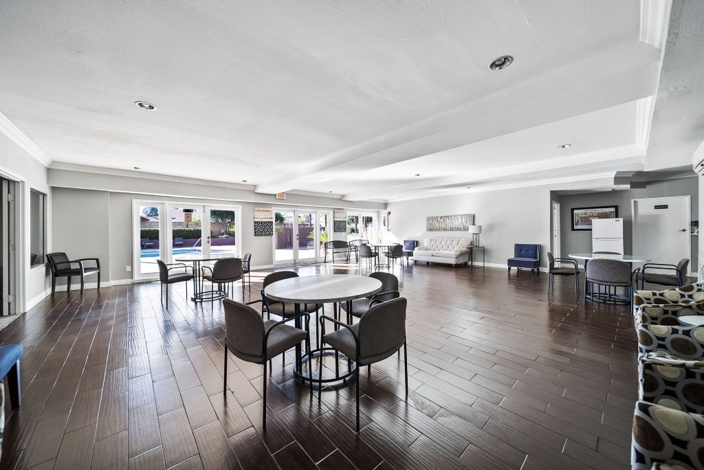 A spacious room with a table and chairs in the foreground and a couch in the background.