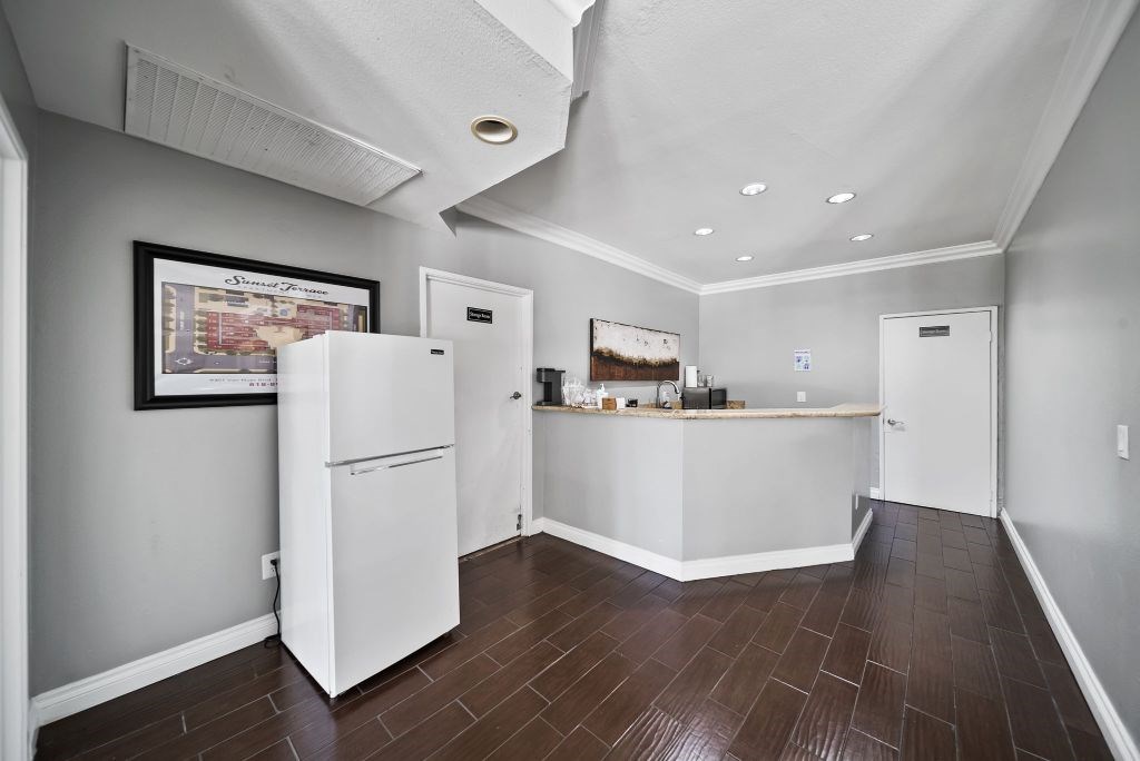 A kitchen with white appliances and wood floors.