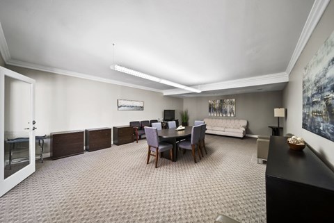 A living room with a grey carpet and a black piano.