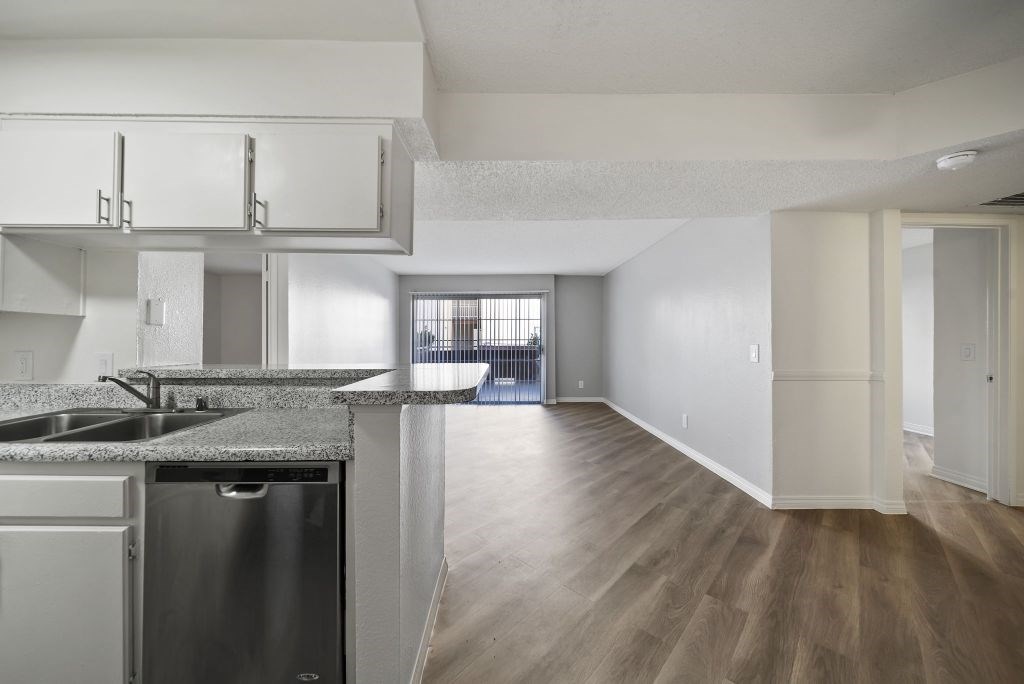 A kitchen with a granite countertop and stainless steel appliances.