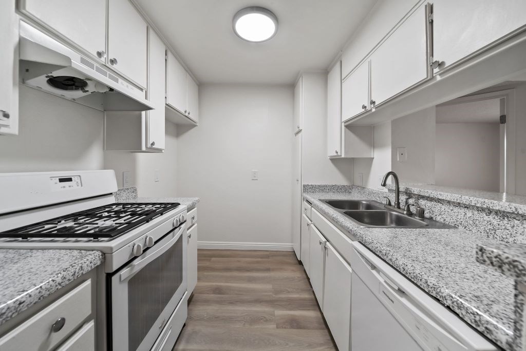 A kitchen with a stove top oven and a sink.
