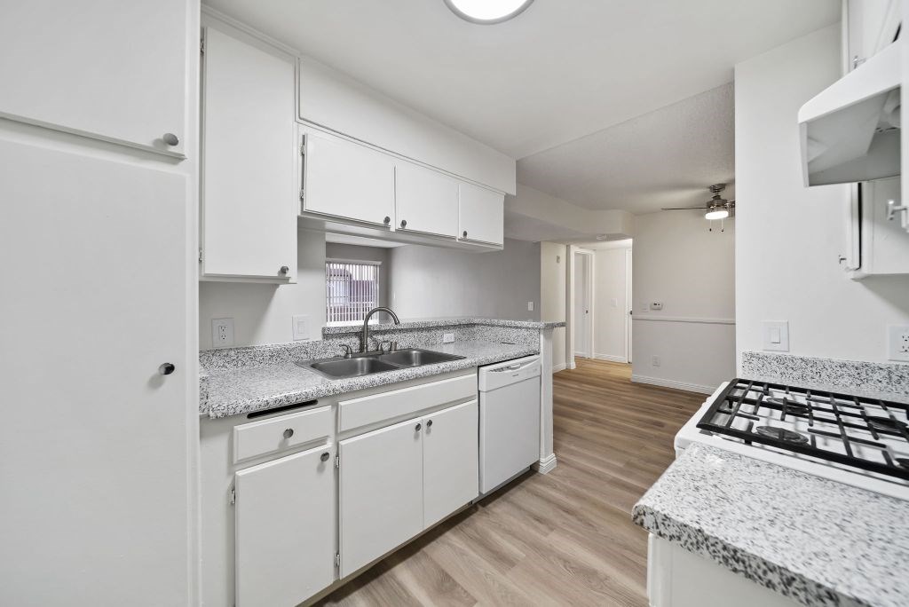 A kitchen with white cabinets and a granite countertop.