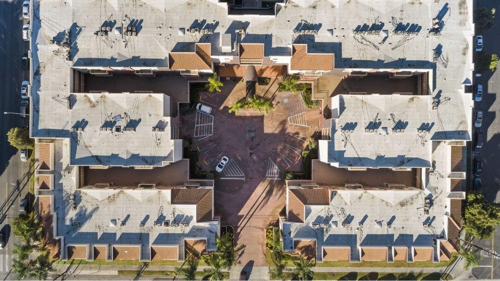 A parking lot is surrounded by a concrete building.