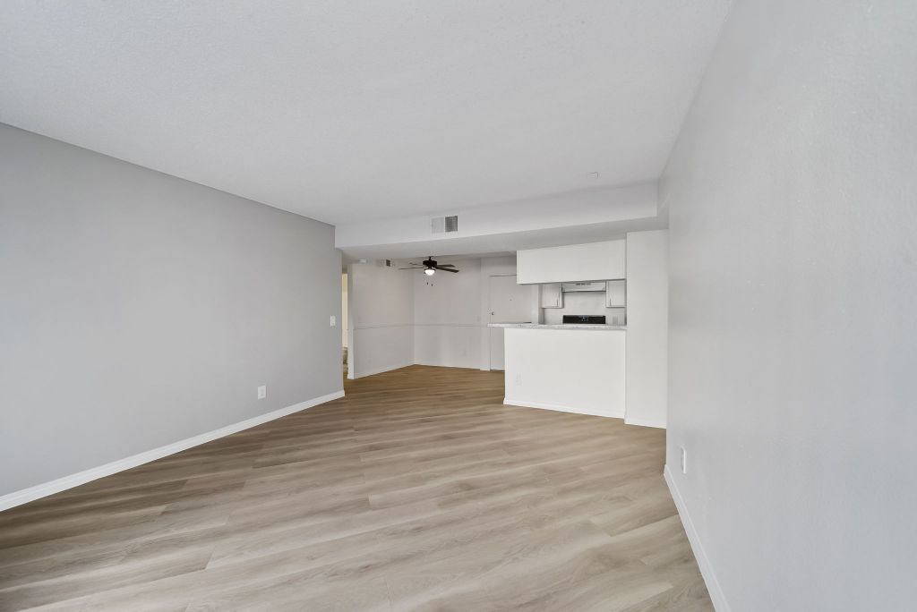 A room with wooden flooring and white walls.
