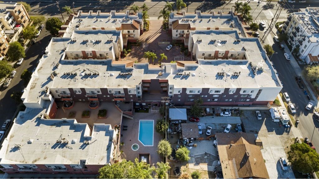 An aerial view of a building with a pool in the middle.