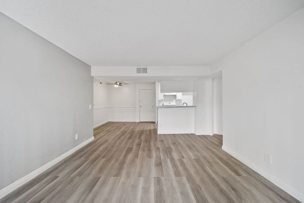 A room with wooden flooring and white walls.