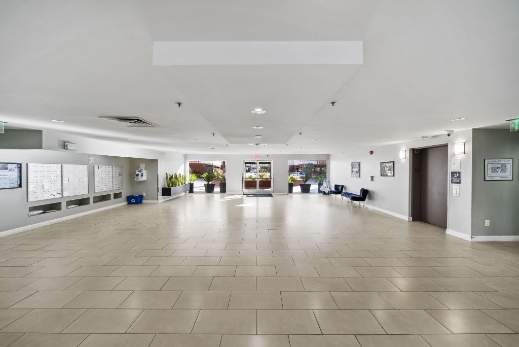 A spacious room with a tiled floor and white walls.