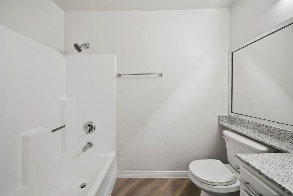 A white bathroom with a toilet, sink, and bathtub.