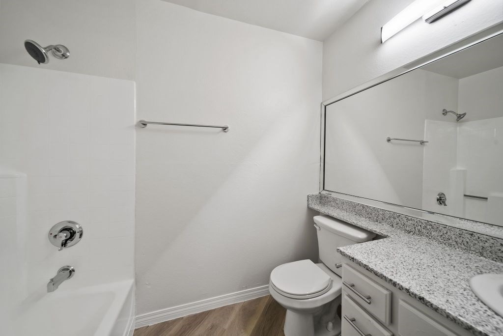 A white bathroom with a toilet, sink, and shower.