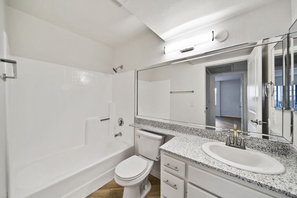 A white bathroom with a toilet, sink, and bathtub.