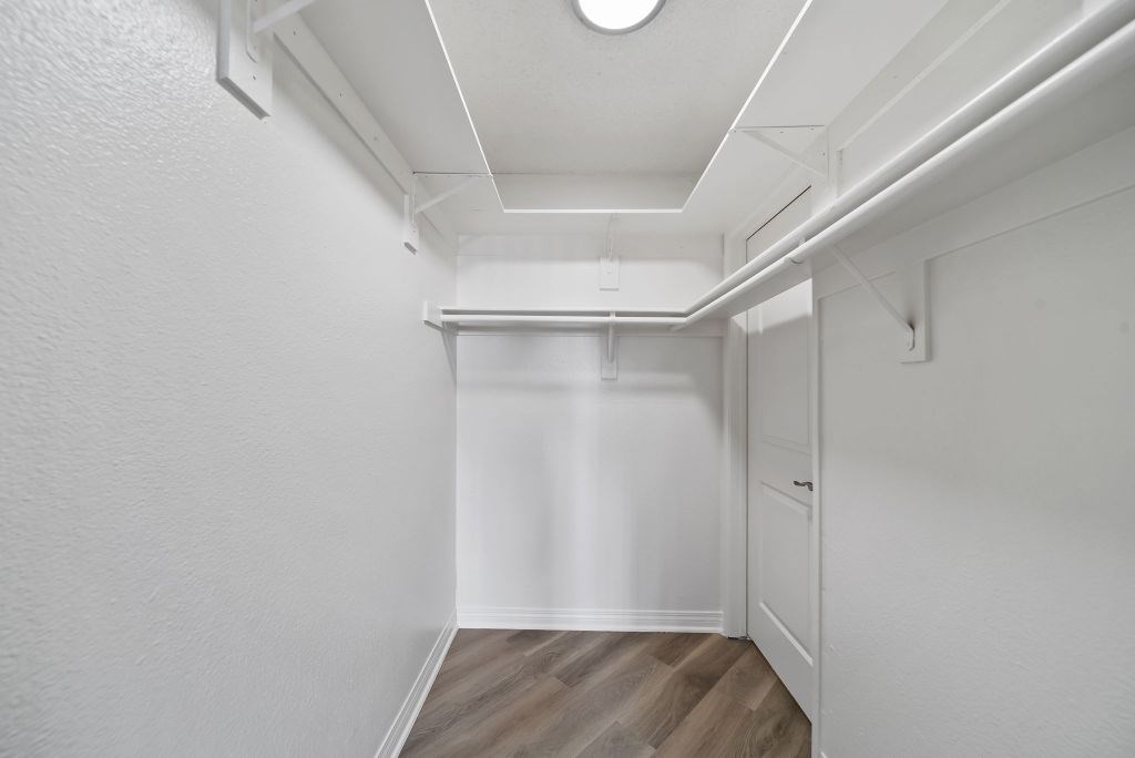 A white hallway with wood flooring and white walls.
