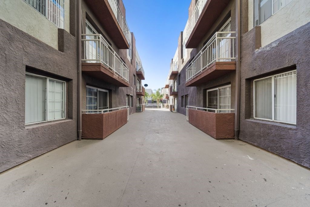 A long, narrow alleyway between two buildings with balconies.
