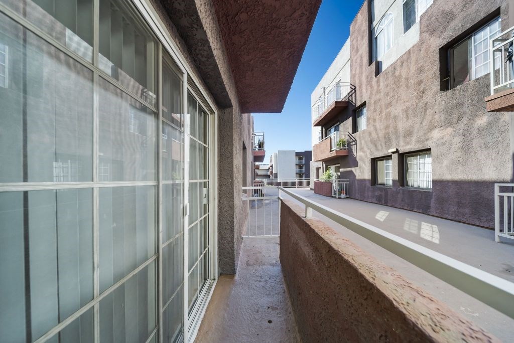 A long, narrow alleyway between two buildings with balconies.