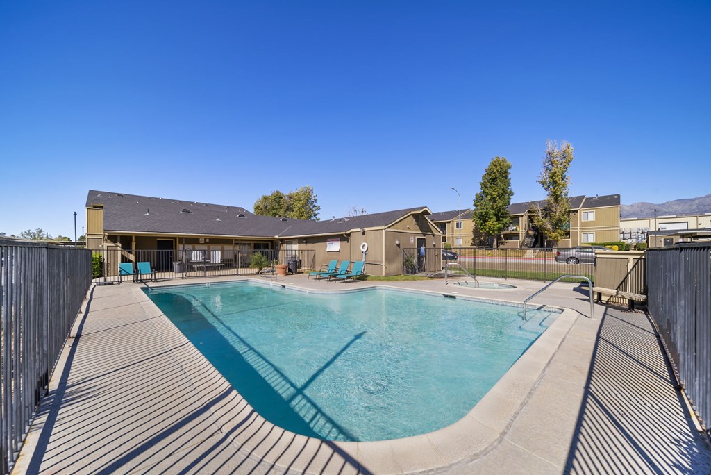 A large outdoor swimming pool surrounded by a wooden deck.