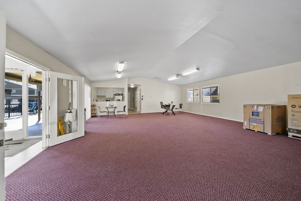 A large room with a carpeted floor and white walls.
