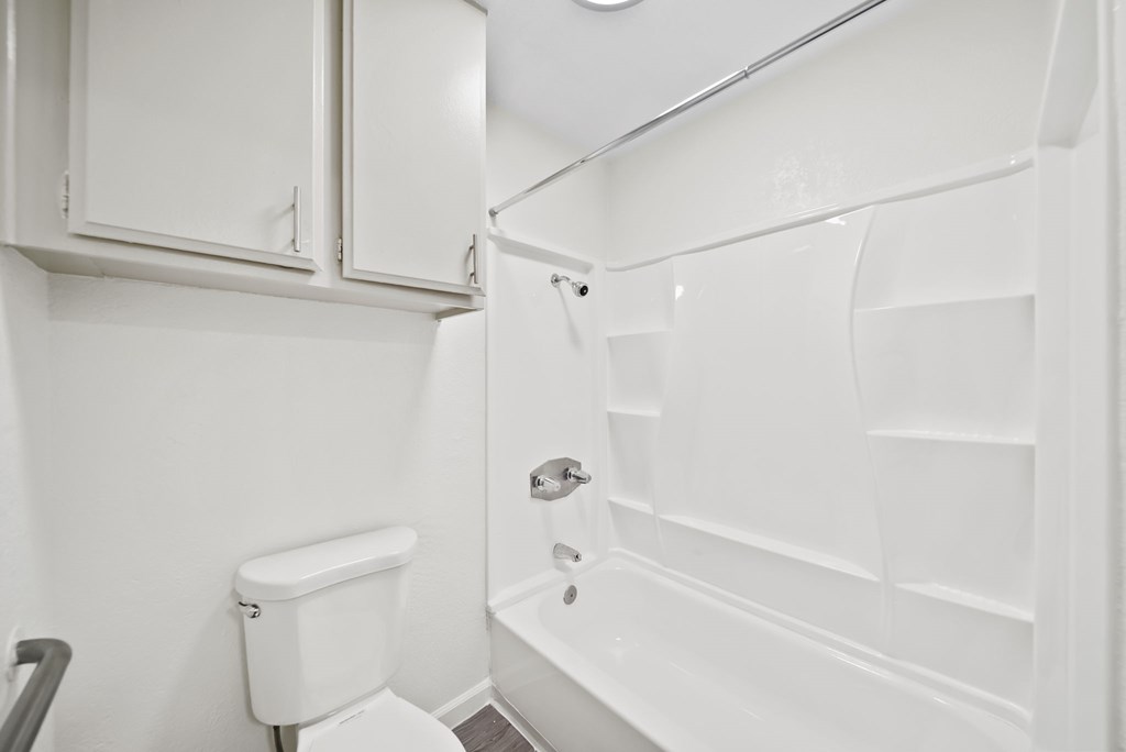 A white bathroom with a toilet, sink, and bathtub.