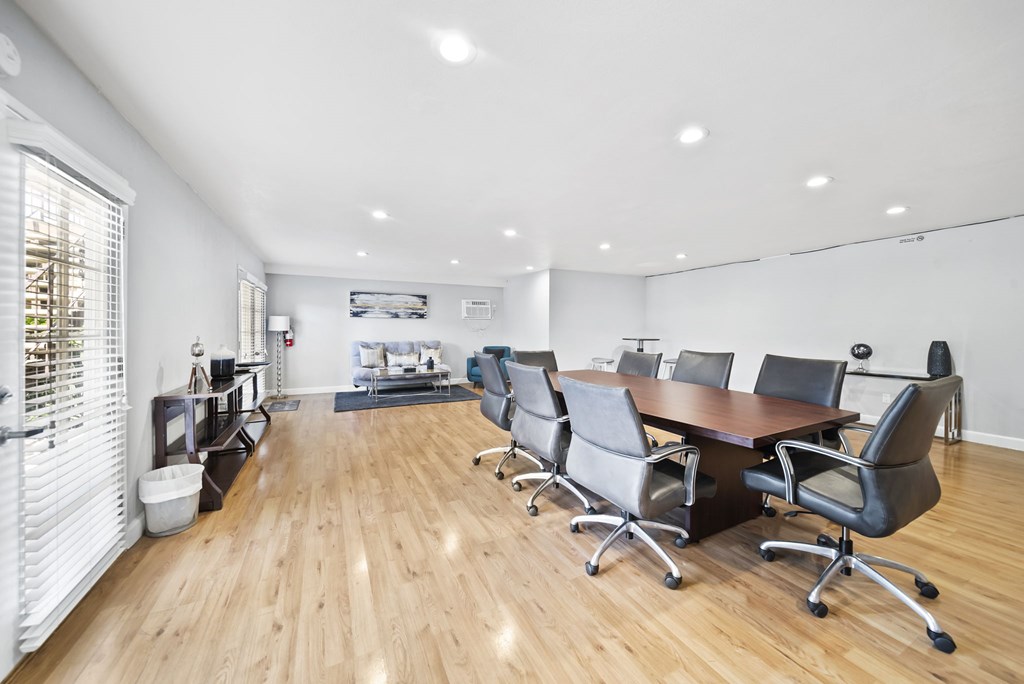 A conference room with a long table and chairs.