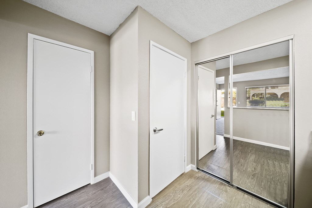 A room with a white door, a white wall, and a glass door.