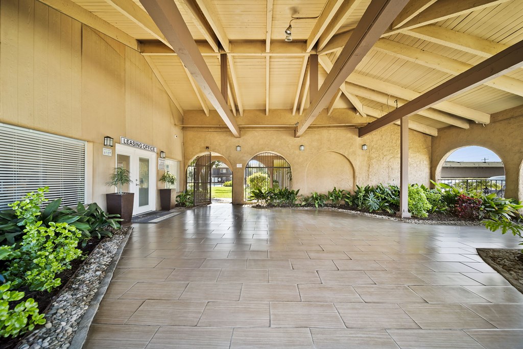 A long hallway with a stone floor and arched doorways.