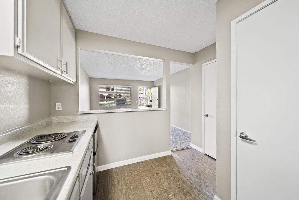 A kitchen with a stove top oven and a window.