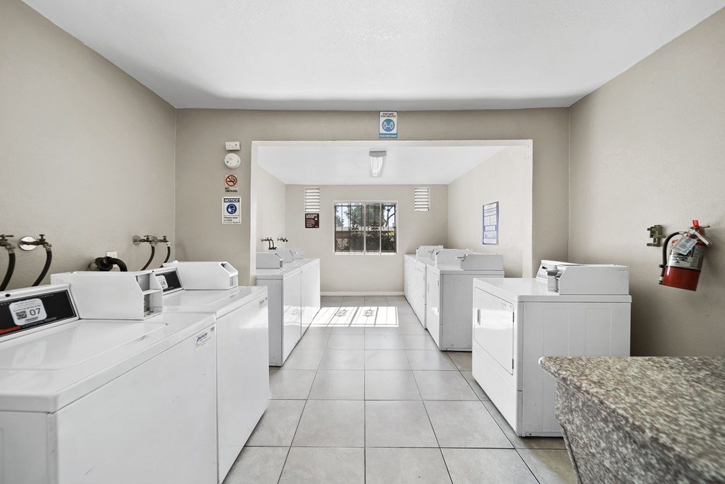 A laundromat with washers and dryers is shown.