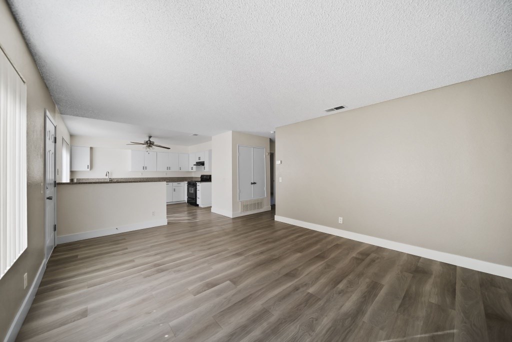 A room with wooden flooring and a ceiling fan.