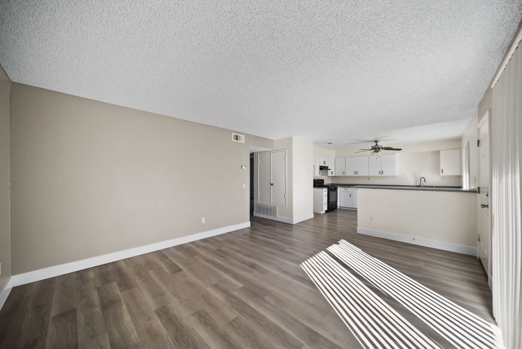 A room with wooden flooring and a striped rug in the middle.