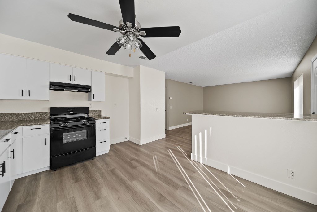 A kitchen with a black stove top oven and white cabinets.