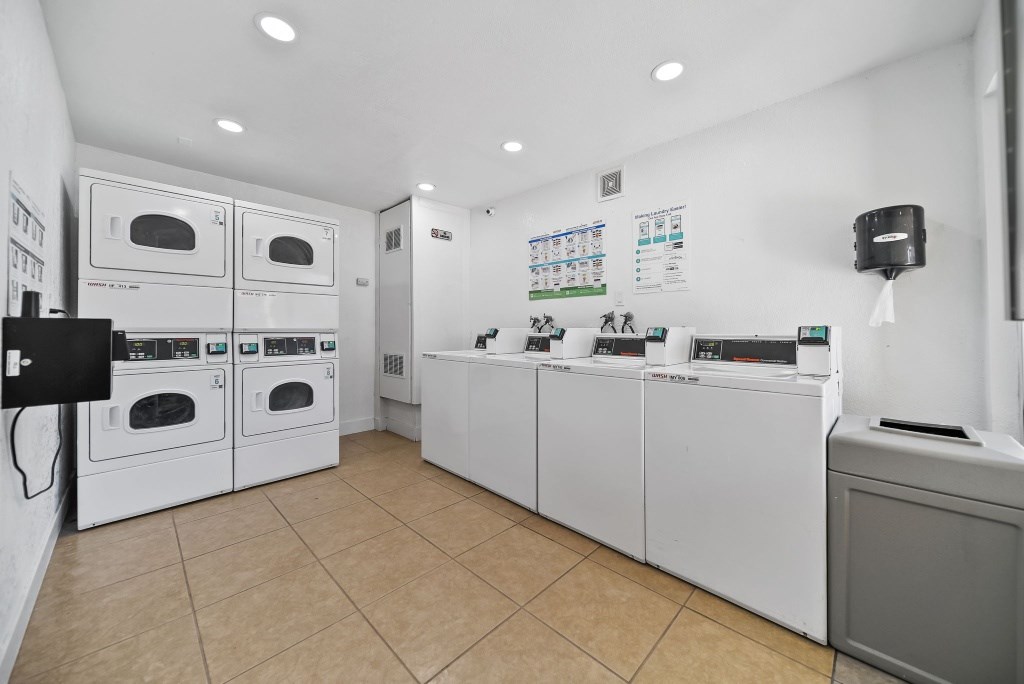 A laundry room with washing machines and dryers.