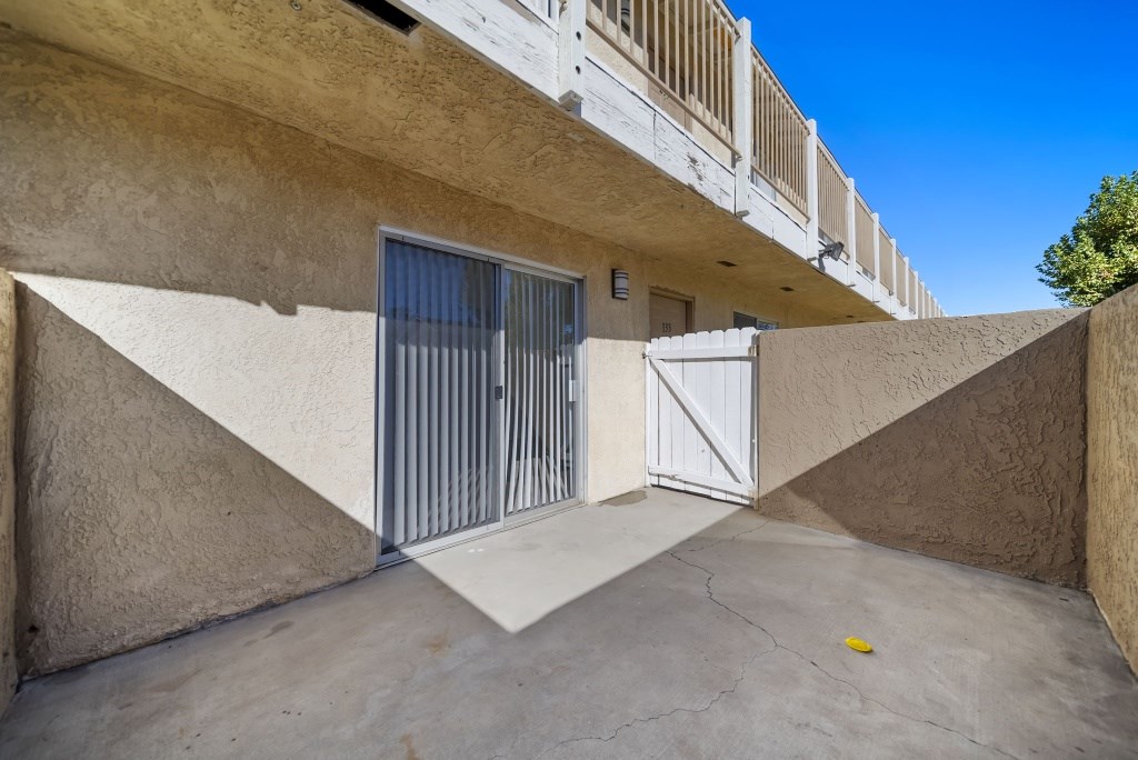 A concrete building with a white gate and a yellow object on the ground.