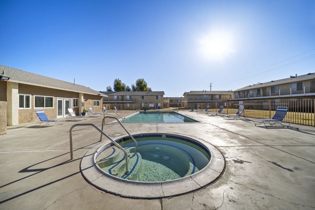 A sunny day at the outdoor pool with a hot tub.