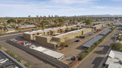 A parking lot with cars and a building in the background.