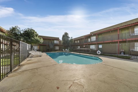 A pool in a courtyard surrounded by a fence.