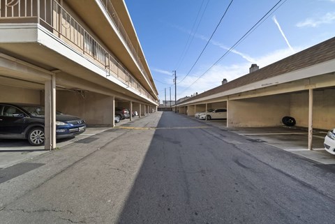 A long, narrow street with cars parked on both sides.