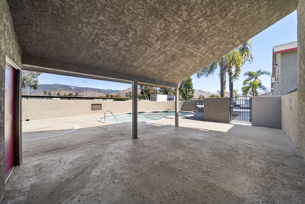 A concrete patio with a pool table and a fence.