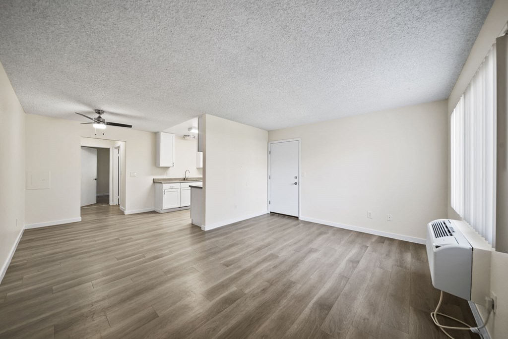 A room with a ceiling fan and a window with blinds.