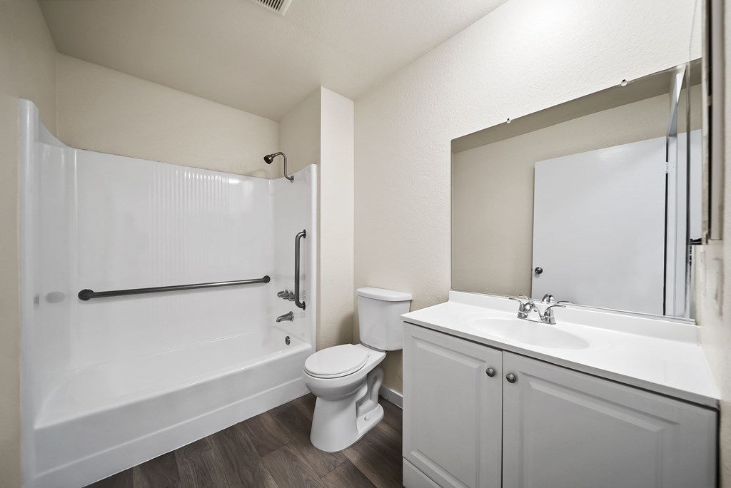 A white bathroom with a toilet, sink, and shower.