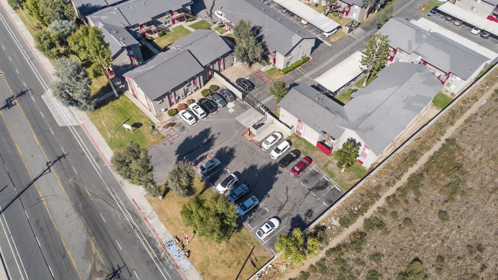 A parking lot with several cars and a building in the background.