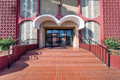 A red brick walkway leads to a building entrance.