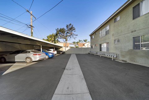 A parking lot with cars parked and a building on the right.