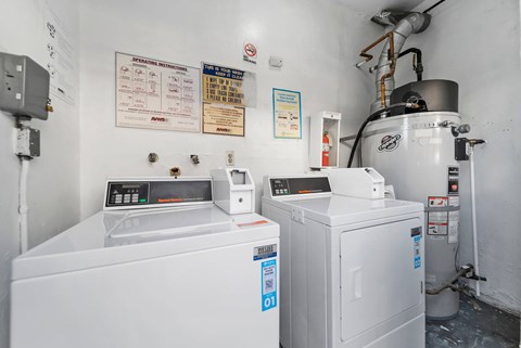 A white industrial machine sits in a room with a white wall and a sign that says "OPERATION INSTRUCTIONS" on the wall.