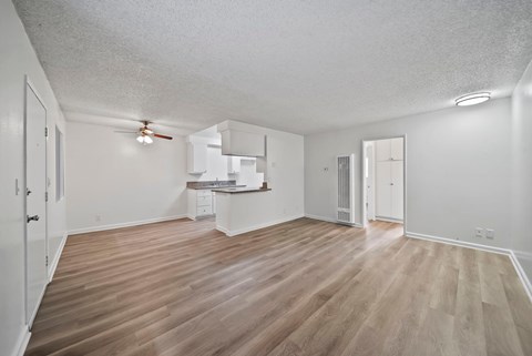 A room with wooden flooring and white walls.