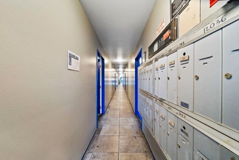 A long hallway with a series of lockers on the right and a door at the end.