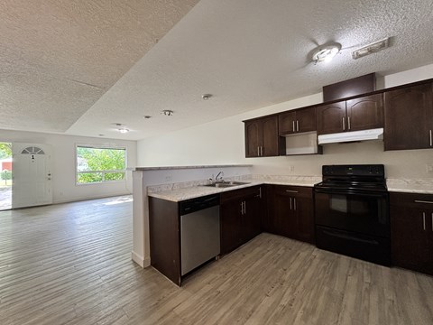A kitchen with dark wood cabinets and a black oven.