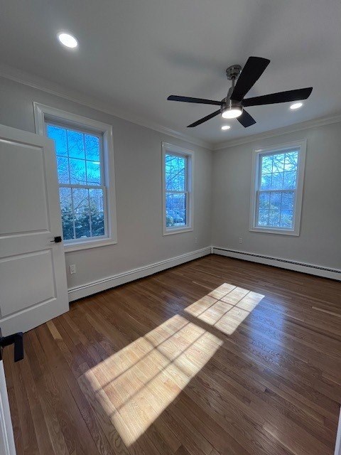 A room with a ceiling fan and two windows.