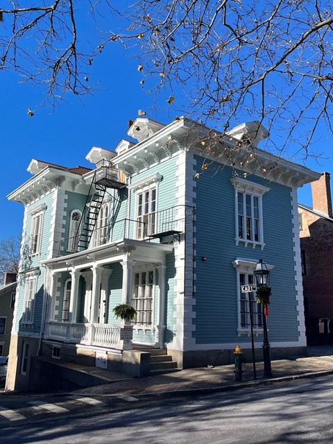 A blue Victorian style house with a sign that says "FARR".