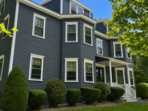 A blue house with white trim and windows.