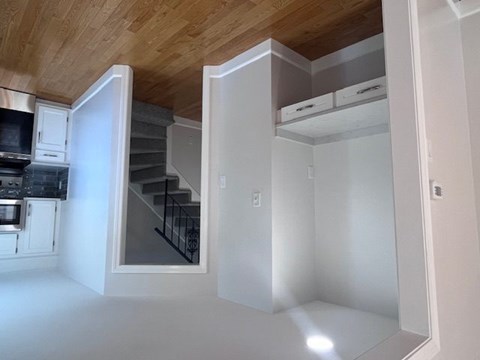 A kitchen with a staircase leading to the upper floor.